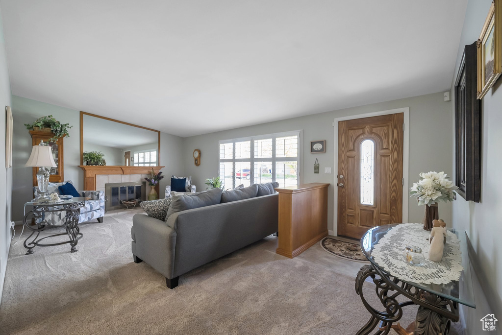 Living area featuring a tiled fireplace and light carpet