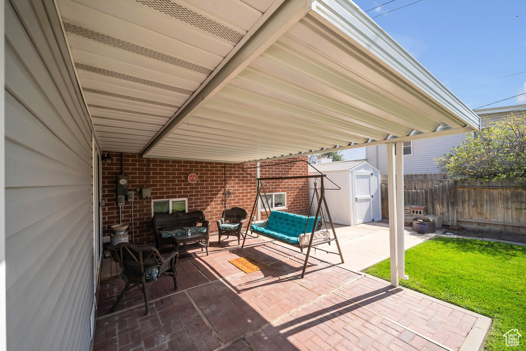 View of patio with an outdoor living space, fence, an outbuilding, and a shed