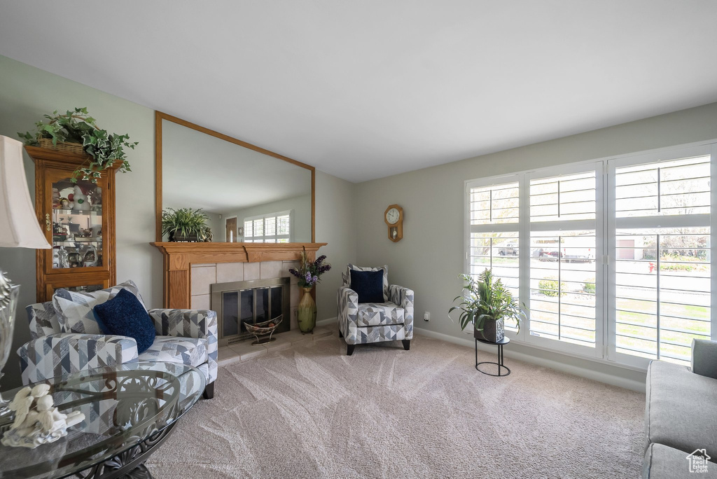 Carpeted living area featuring baseboards, vaulted ceiling, and a tiled fireplace