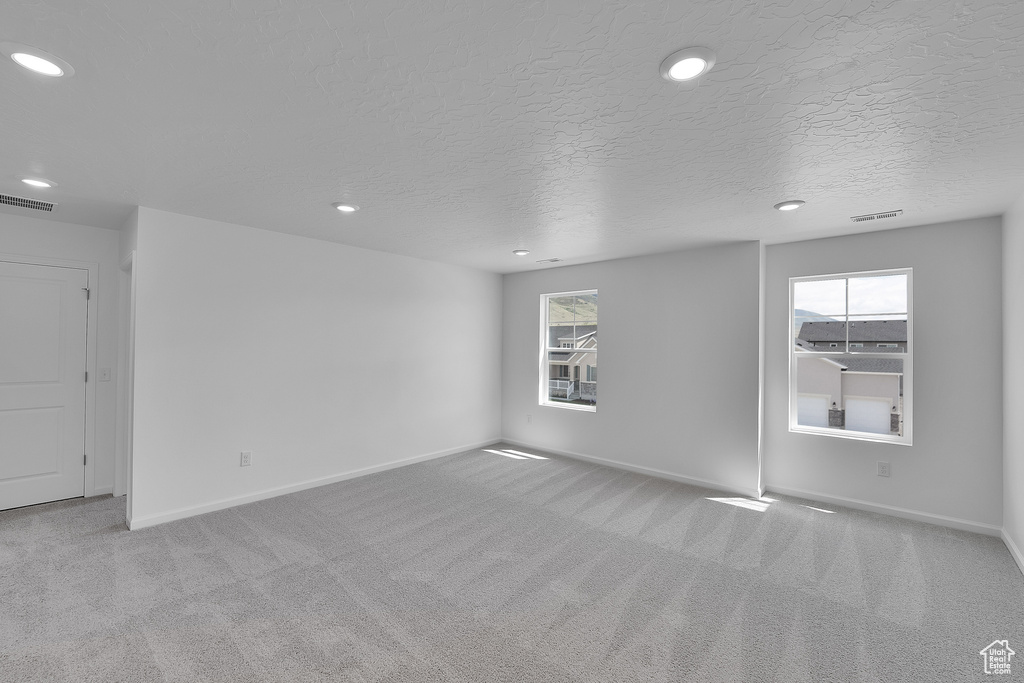 Unfurnished room featuring carpet, recessed lighting, baseboards, and a textured ceiling