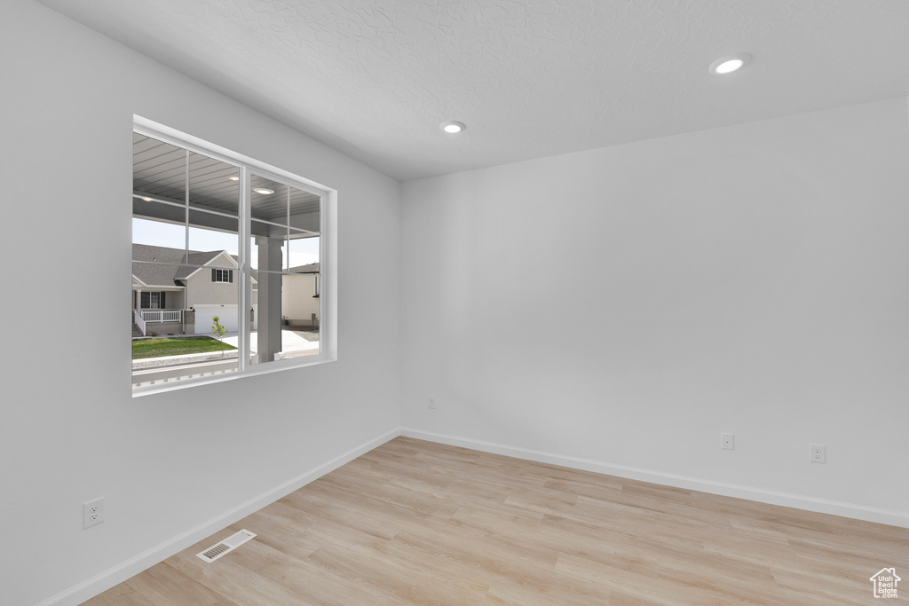 Empty room with wood finished floors, baseboards, and recessed lighting