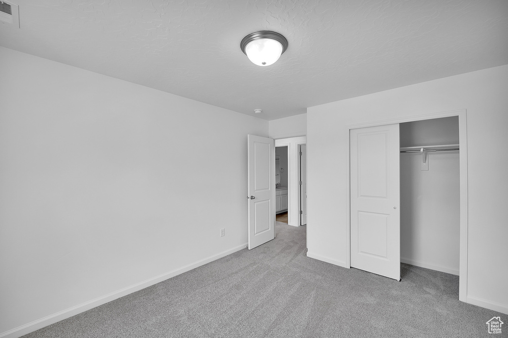Unfurnished bedroom with carpet, baseboards, and a closet