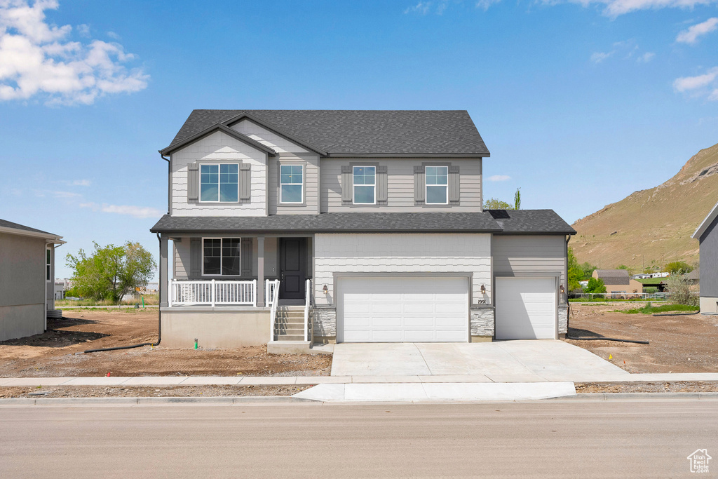 View of front of home with a porch, driveway, a garage, and a shingled roof