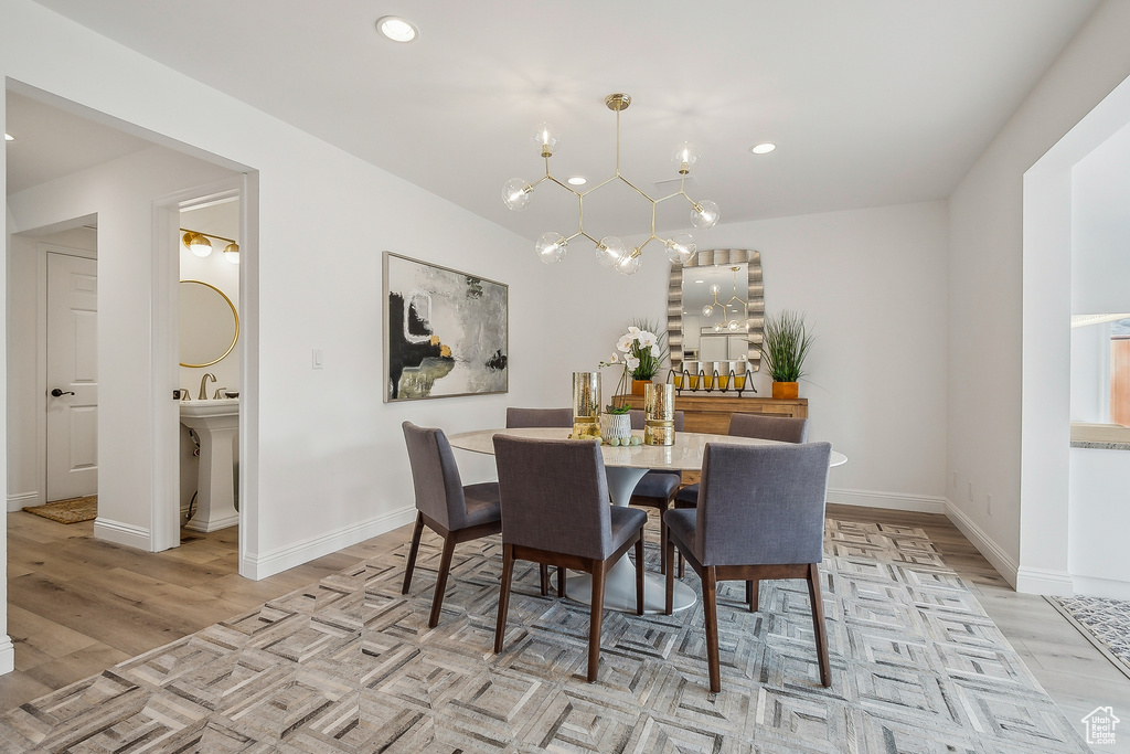 Dining space featuring recessed lighting, light wood-type flooring, baseboards, and a notable chandelier