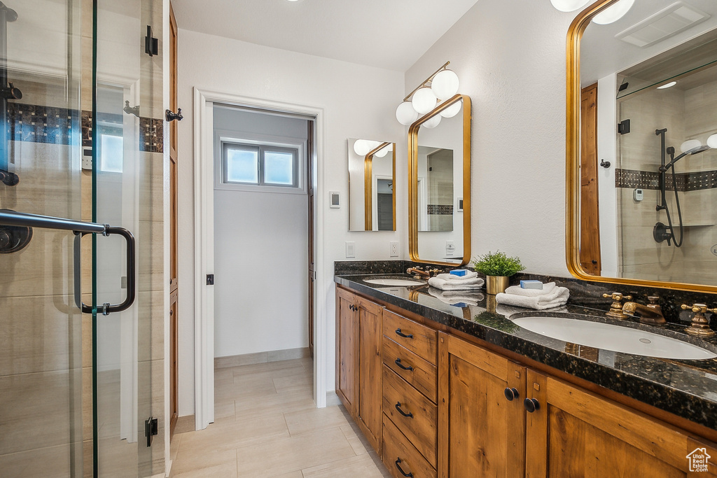 Full bath featuring a shower stall, a sink, and visible vents