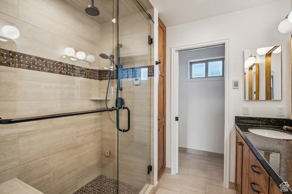Full bath featuring a shower stall, baseboards, vanity, and tile patterned flooring