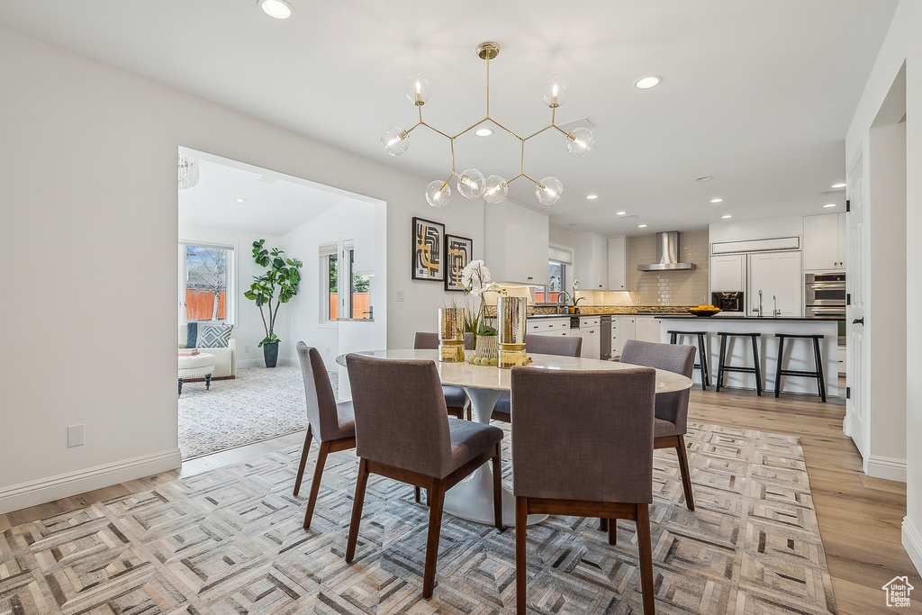Dining room featuring baseboards, light wood-style floors, and recessed lighting