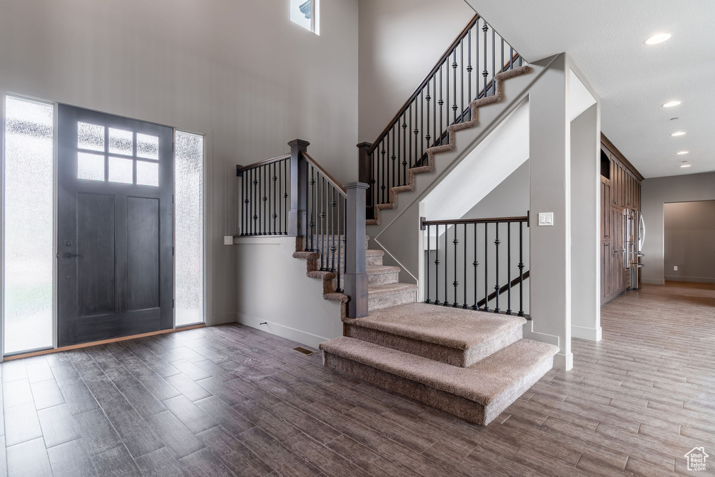 Entrance foyer with stairway, baseboards, and wood finished floors