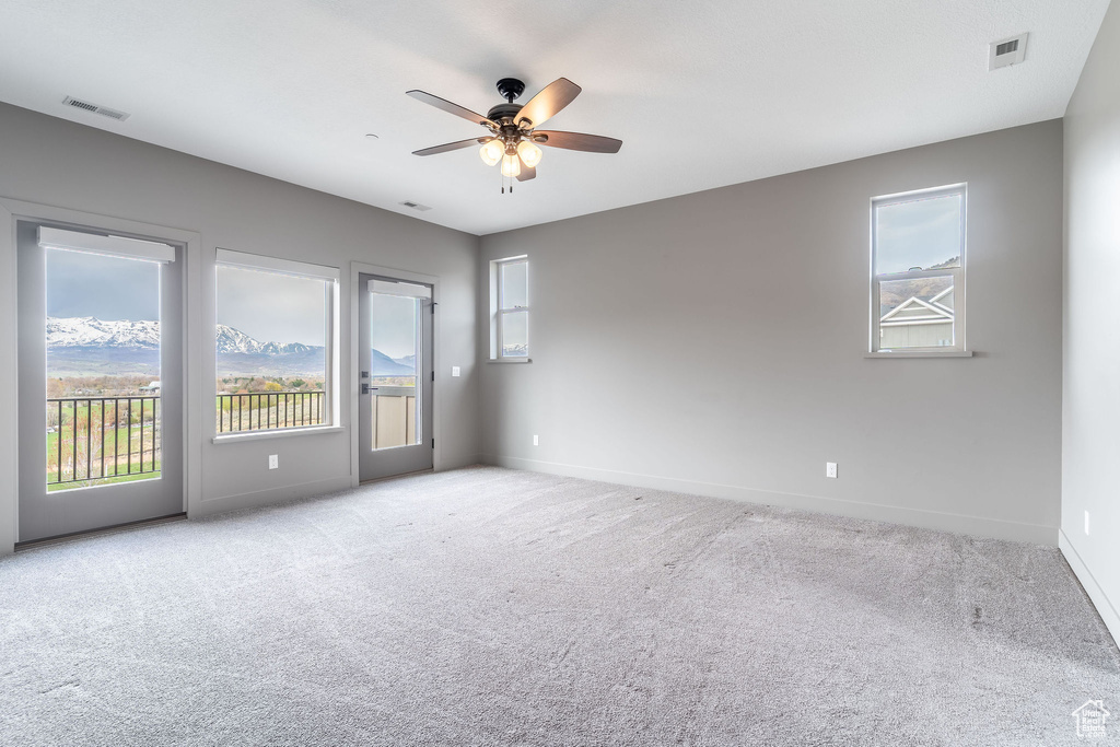 Empty room with visible vents, baseboards, and a wealth of natural light