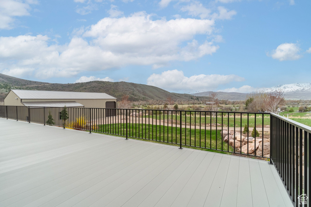 Wooden terrace featuring an outdoor structure and a mountain view