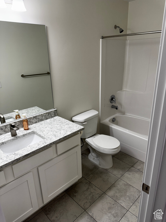 Full bathroom featuring vanity, tile patterned flooring,  shower combination, and toilet