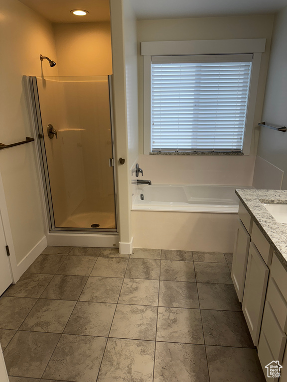 Full bath featuring recessed lighting, tile patterned floors, vanity, a garden tub, and a stall shower