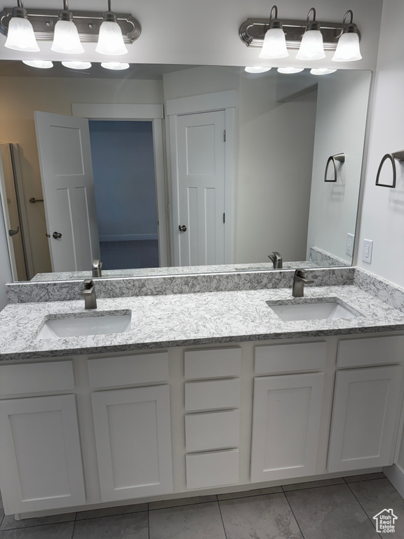 Full bathroom featuring tile patterned flooring, a sink, and double vanity
