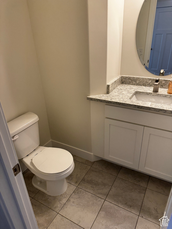 Bathroom featuring toilet, vanity, and tile patterned floors