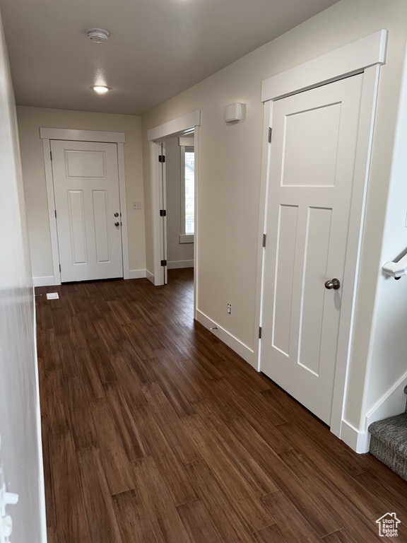 Entryway featuring baseboards, dark wood-type flooring, and stairway