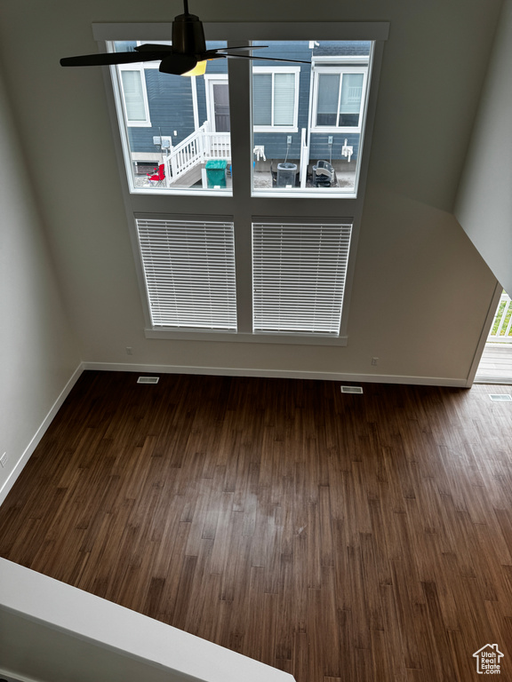 Unfurnished dining area with wood finished floors, baseboards, and a ceiling fan