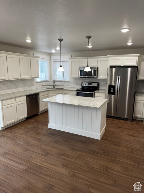 Kitchen featuring white cabinets, stainless steel appliances, a sink, and backsplash