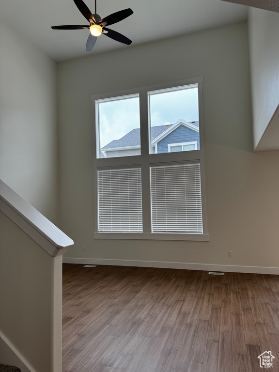 Unfurnished room featuring baseboards, wood finished floors, and ceiling fan