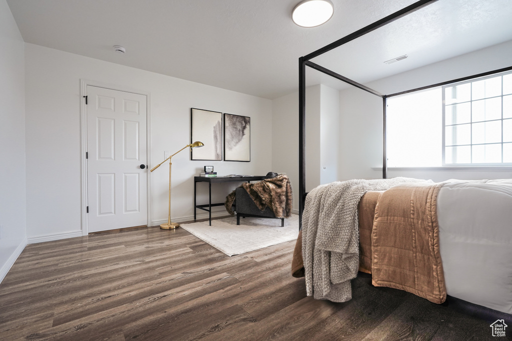 Bedroom featuring dark wood-style floors and baseboards