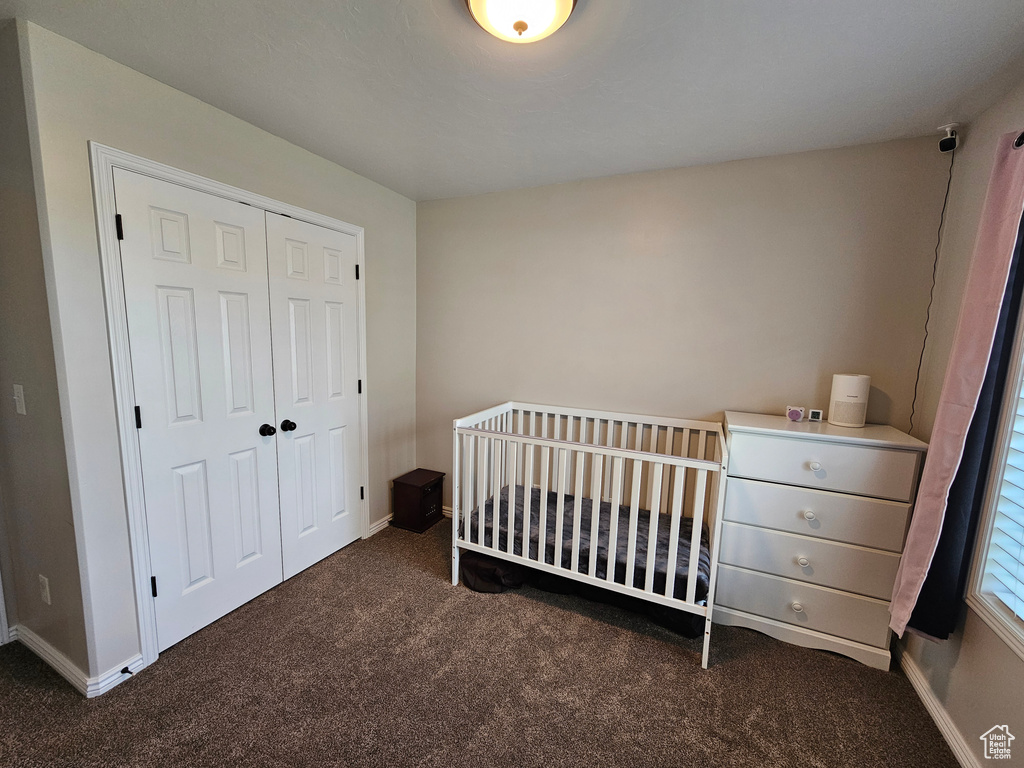 Carpeted bedroom featuring a closet and baseboards