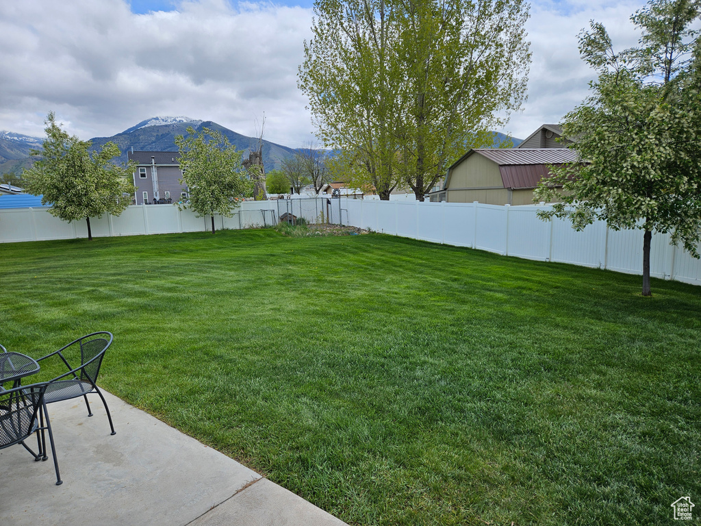 View of yard featuring a mountain view, a patio, and fence
