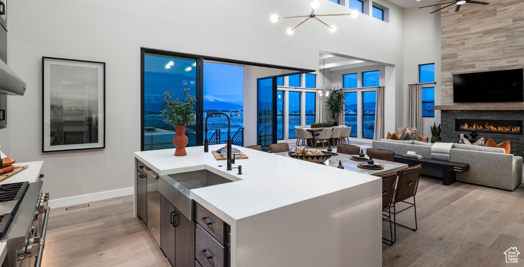 Kitchen with baseboards, a high ceiling, light wood finished floors, and open floor plan