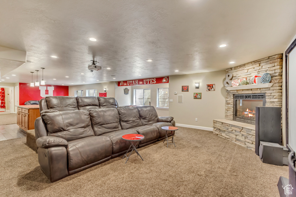 Home theater room featuring recessed lighting, a fireplace, baseboards, and light carpet
