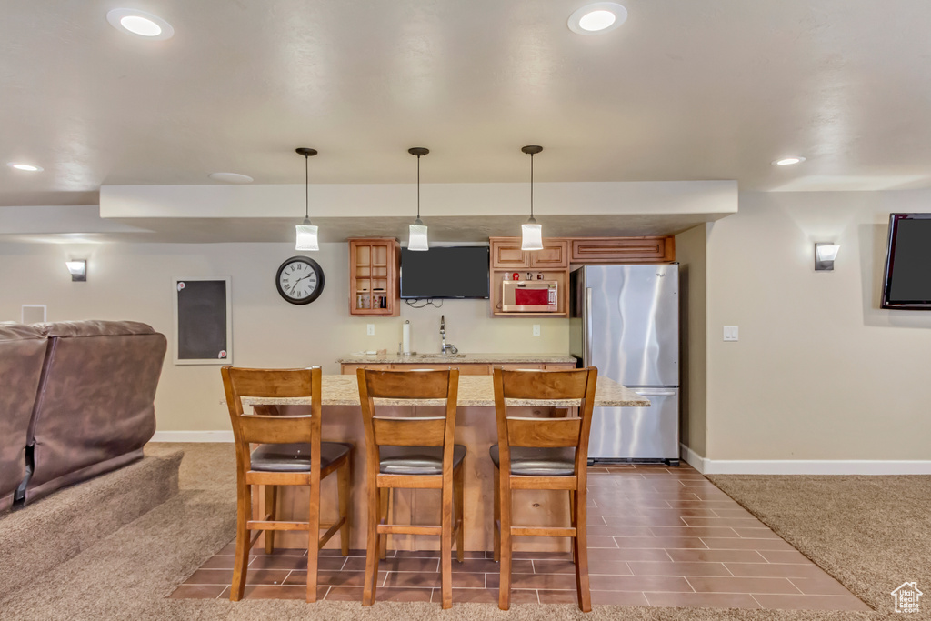 Kitchen featuring stainless steel appliances, baseboards, dark carpet, and brown cabinets