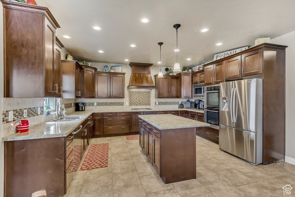 Kitchen featuring recessed lighting, backsplash, a sink, appliances with stainless steel finishes, and custom exhaust hood
