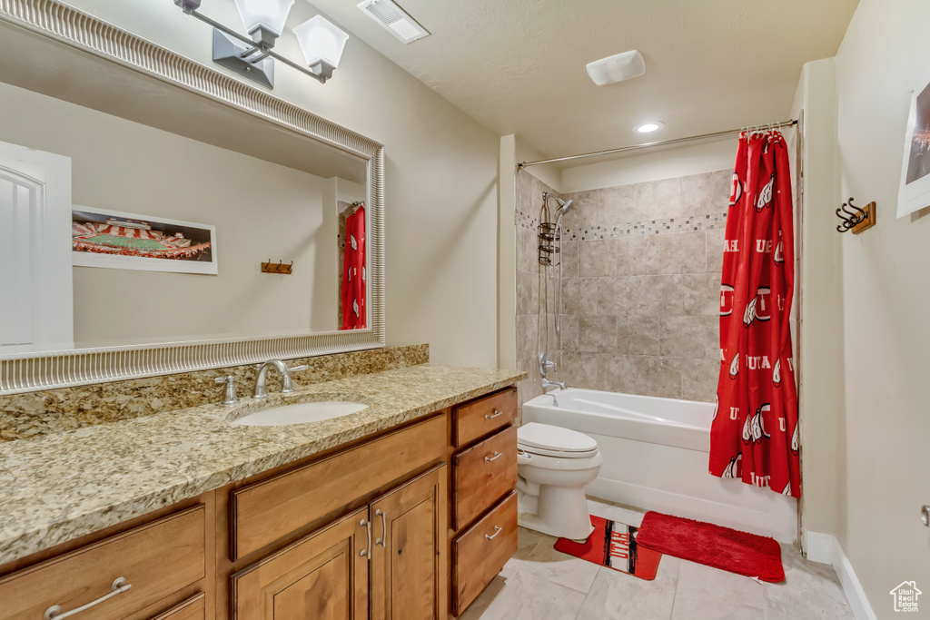 Bathroom featuring toilet, vanity, visible vents, and shower / bathtub combination with curtain