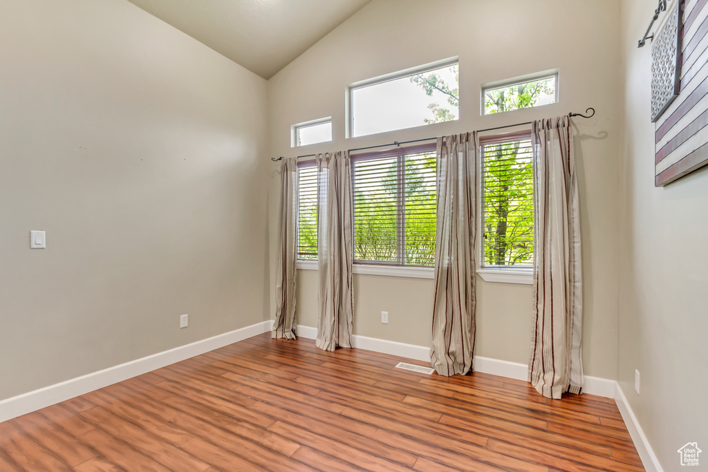 Empty room featuring a healthy amount of sunlight, light wood-style floors, and visible vents