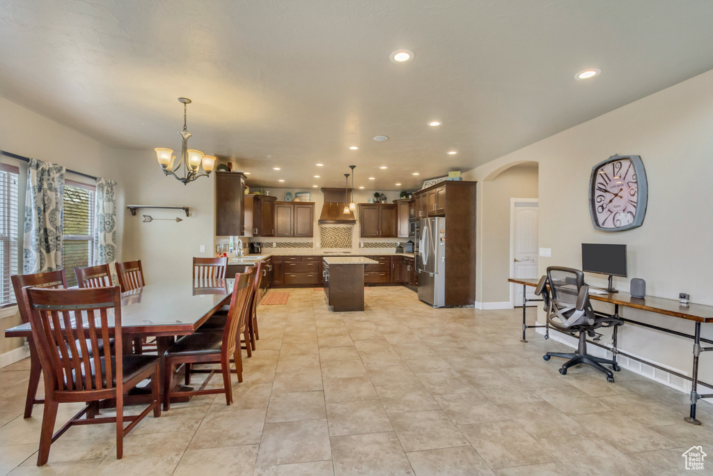Dining room featuring an inviting chandelier, baseboards, arched walkways, and recessed lighting