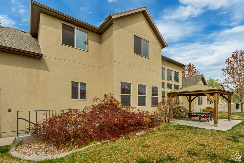 Rear view of house featuring a patio, a gazebo, and stucco siding