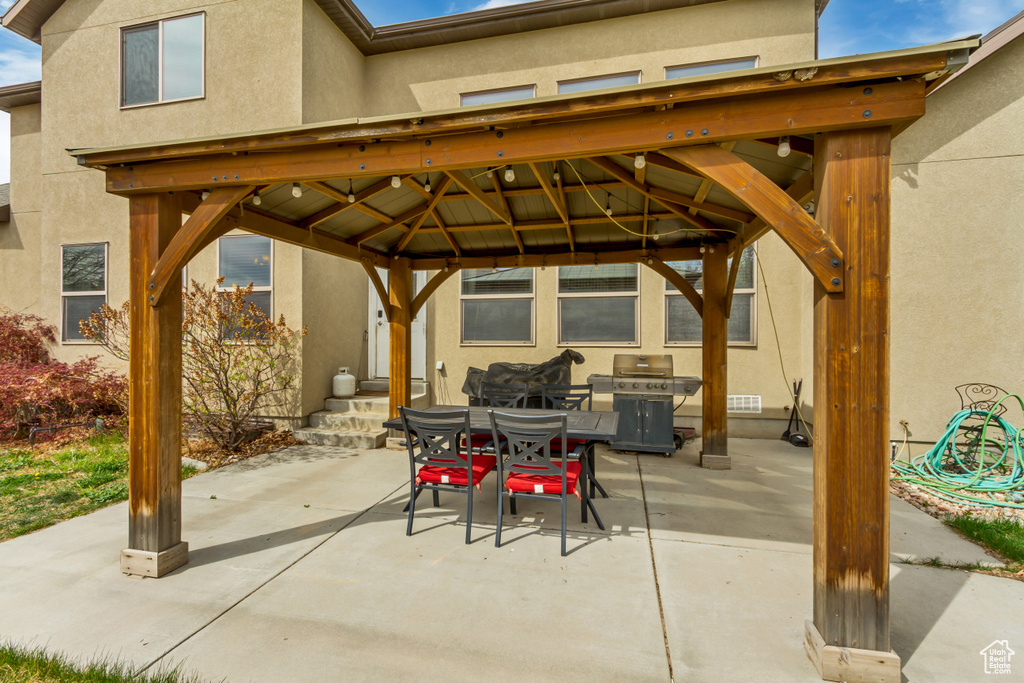 View of patio with a gazebo, outdoor dining space, and area for grilling
