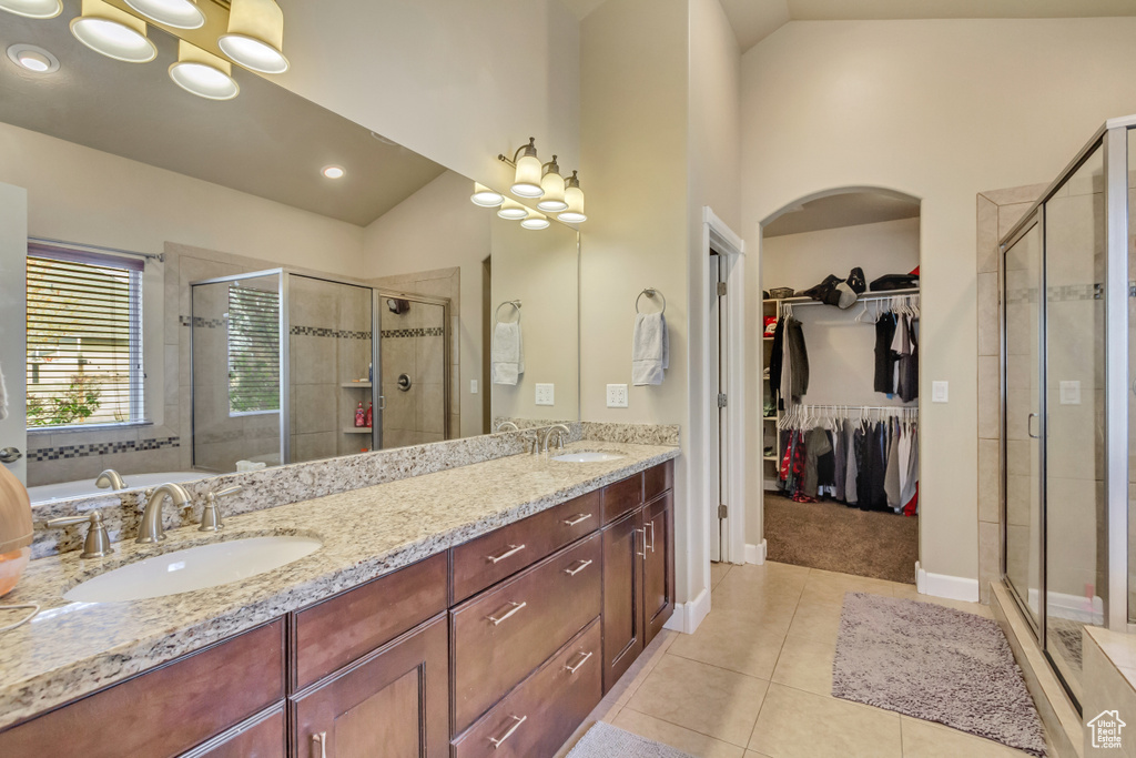 Bathroom with a shower stall, tile patterned flooring, and a sink