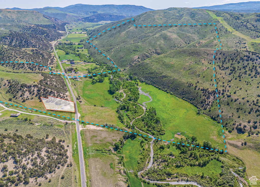 Aerial view of sparsely populated area featuring property parcel outlined and a mountain backdrop