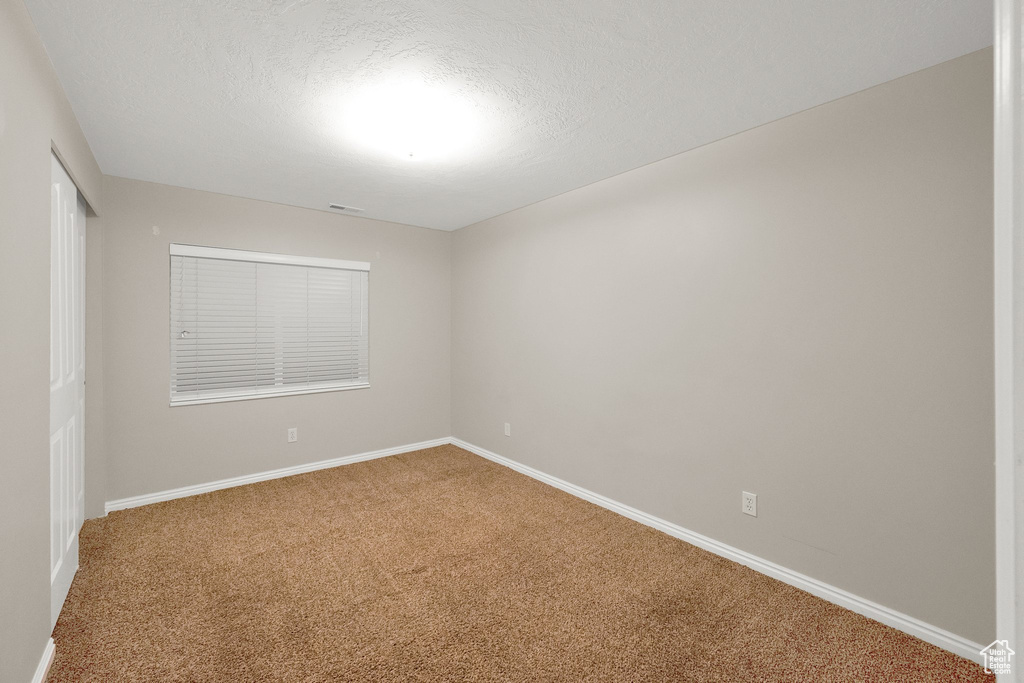 Carpeted empty room featuring baseboards