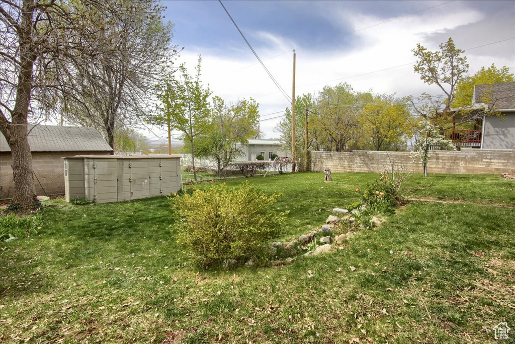 View of yard featuring fence, an outbuilding, and a storage unit