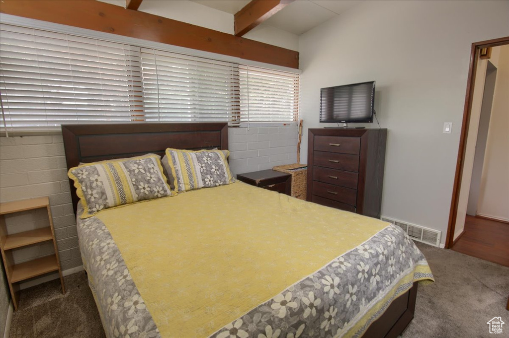Carpeted bedroom featuring beamed ceiling, visible vents, and baseboards
