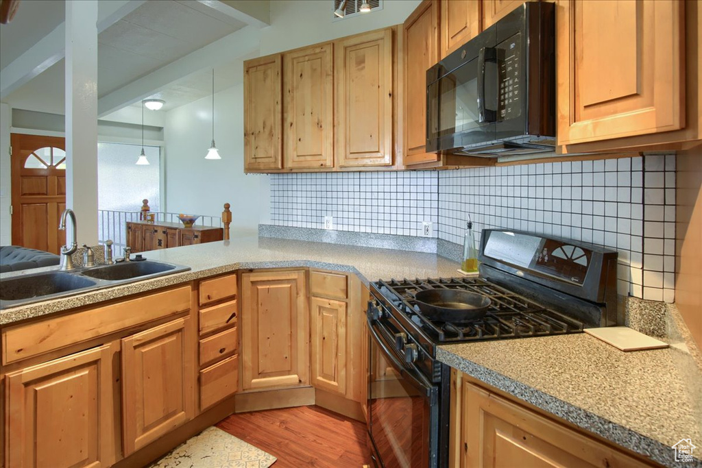 Kitchen with a sink, tasteful backsplash, visible vents, light wood-style floors, and black appliances