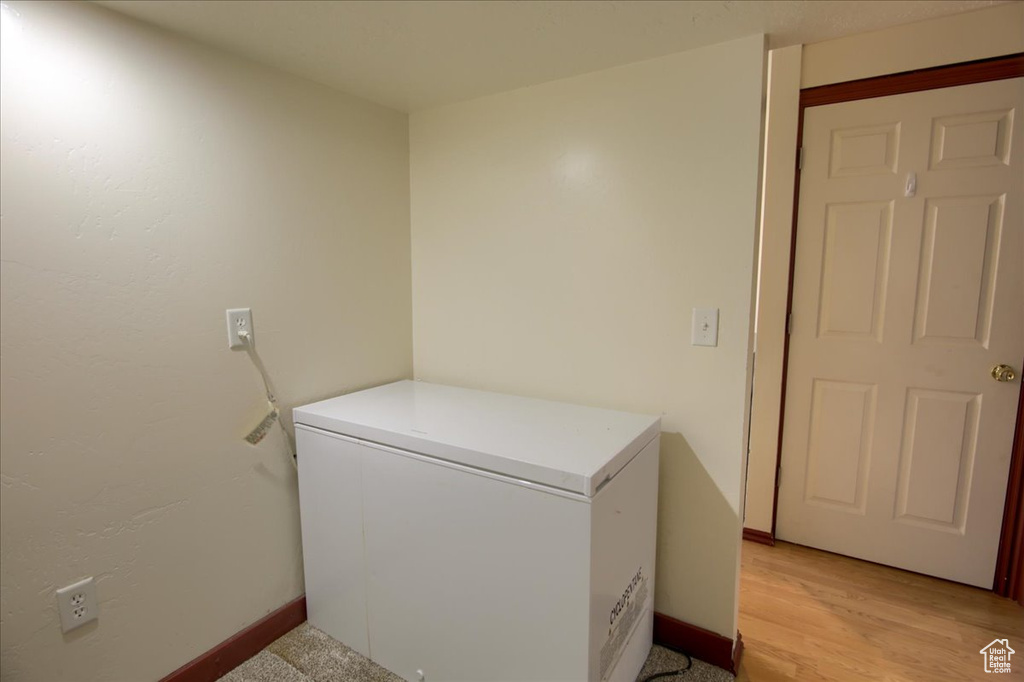 Laundry area with baseboards and light wood-style flooring