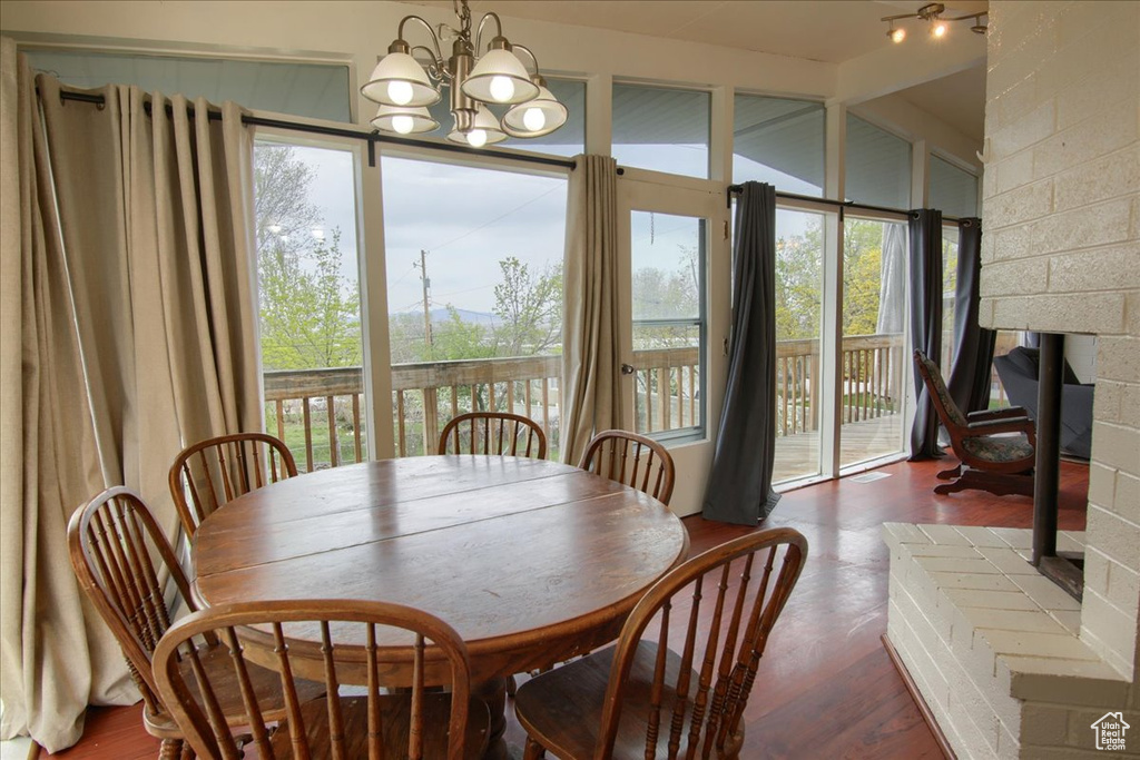 Dining space with a chandelier, lofted ceiling, and wood finished floors