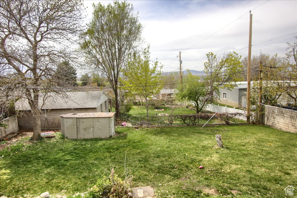 View of yard with a storage shed, fence, and an outdoor structure