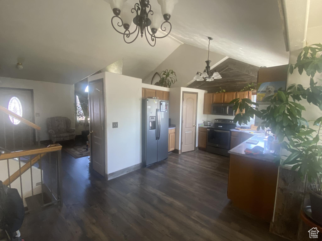 Kitchen featuring stainless steel appliances, a chandelier, dark wood-style floors, and lofted ceiling