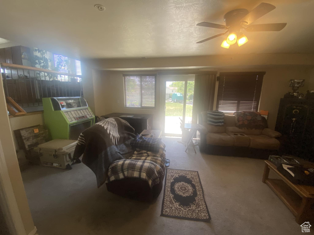 Carpeted living area featuring ceiling fan