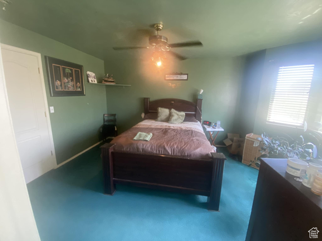 Carpeted bedroom featuring a ceiling fan