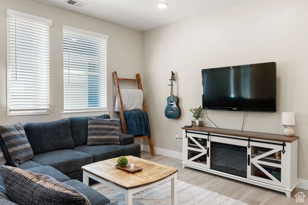 Living area with recessed lighting, light wood-type flooring, visible vents, and baseboards