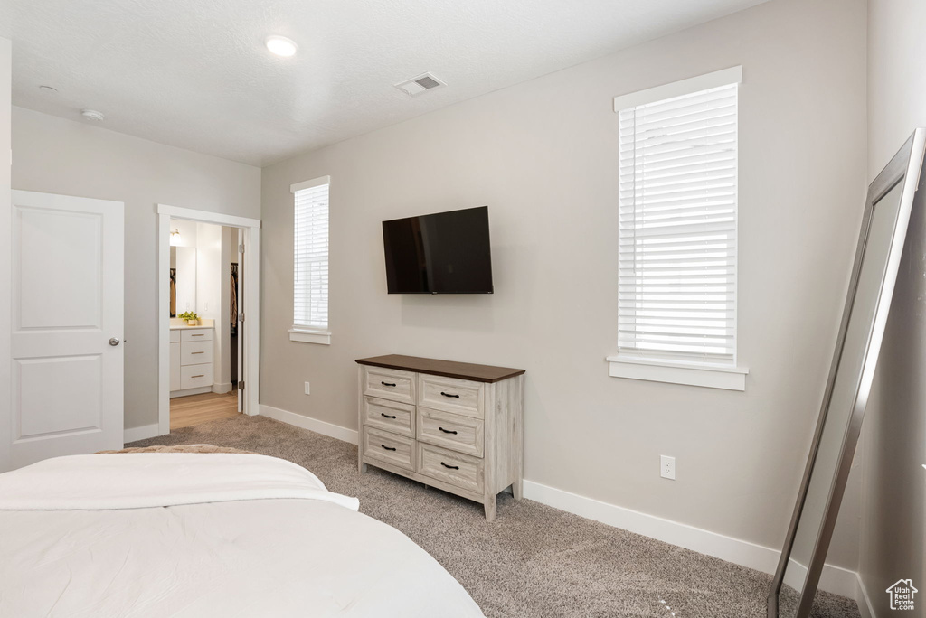 Bedroom featuring visible vents, baseboards, and light colored carpet