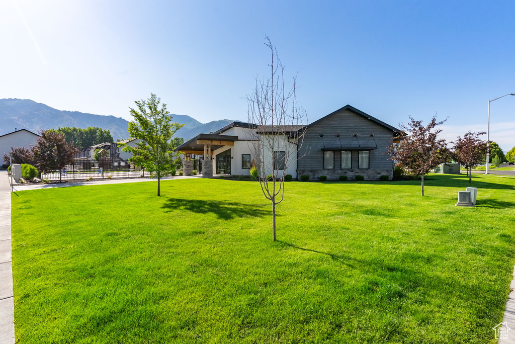 View of front facade with a mountain view and a front yard