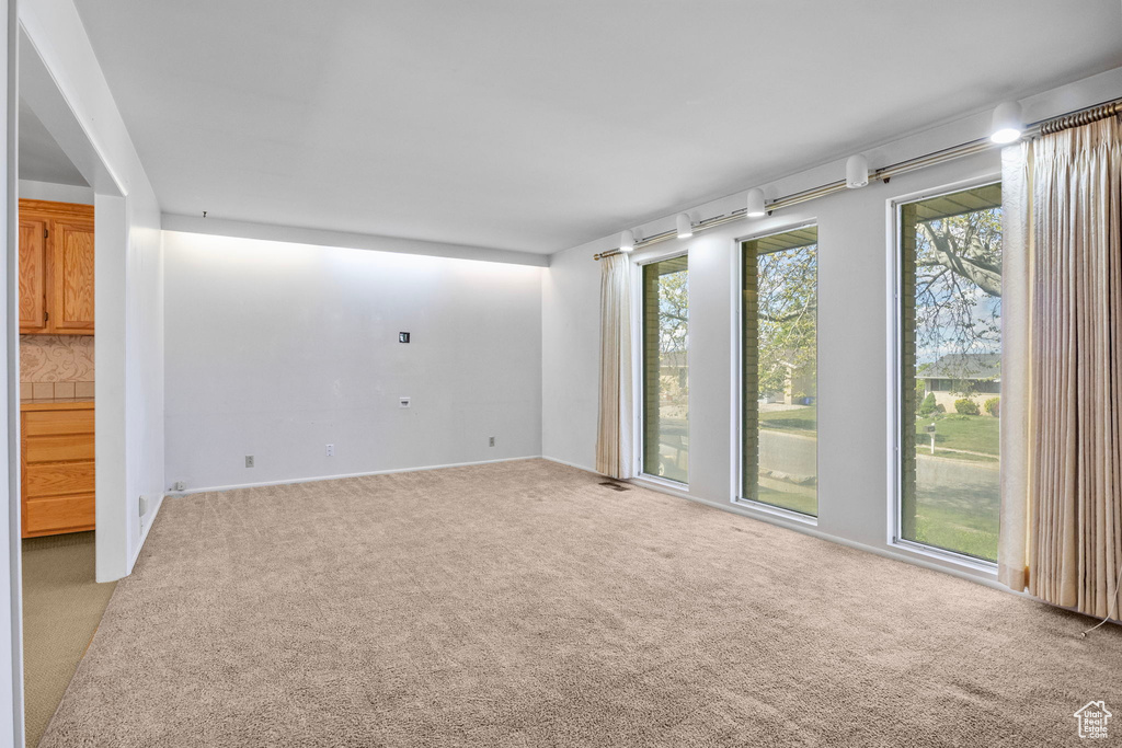 Spare room with baseboards, carpet, and visible vents